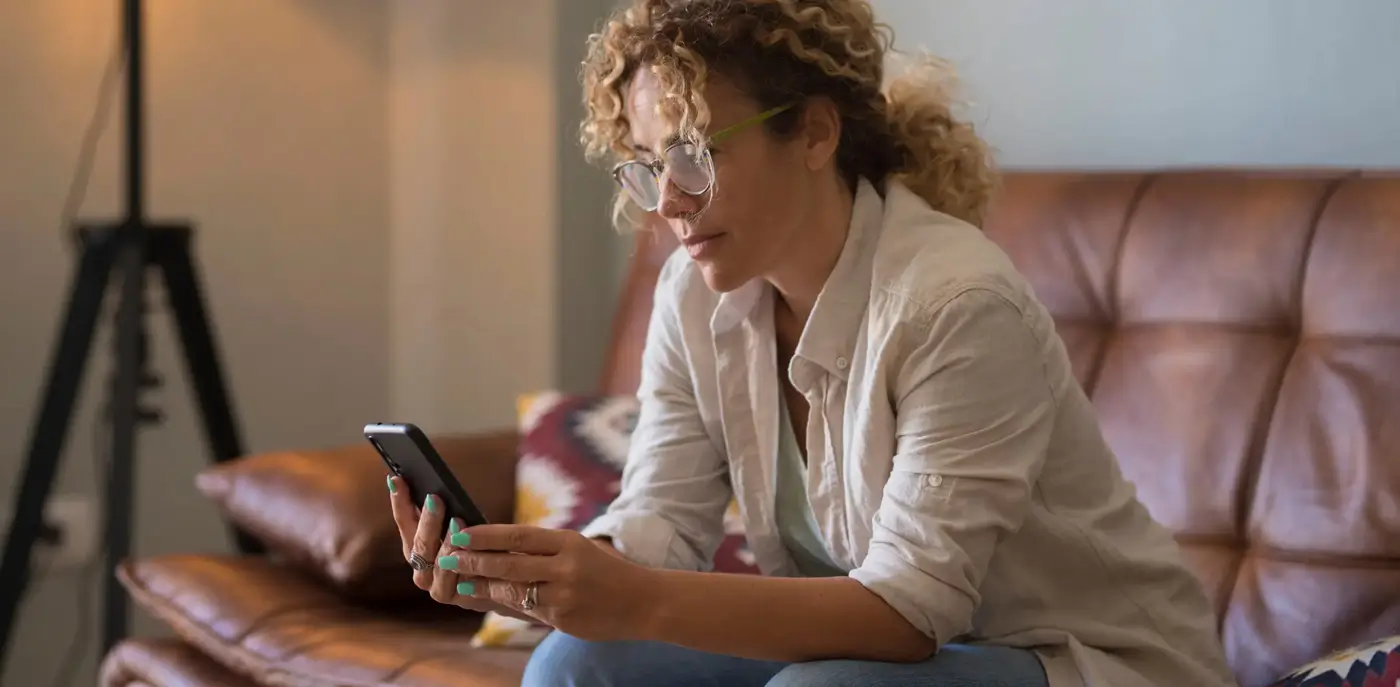 Woman sitting on a couch looking at her phone